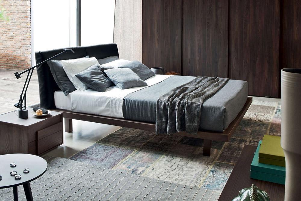 Le lit Novamobili Nido a un cadre en bois et une t&ecirc;te de lit rembourr&eacute;e en cuir v&eacute;ritable noir.