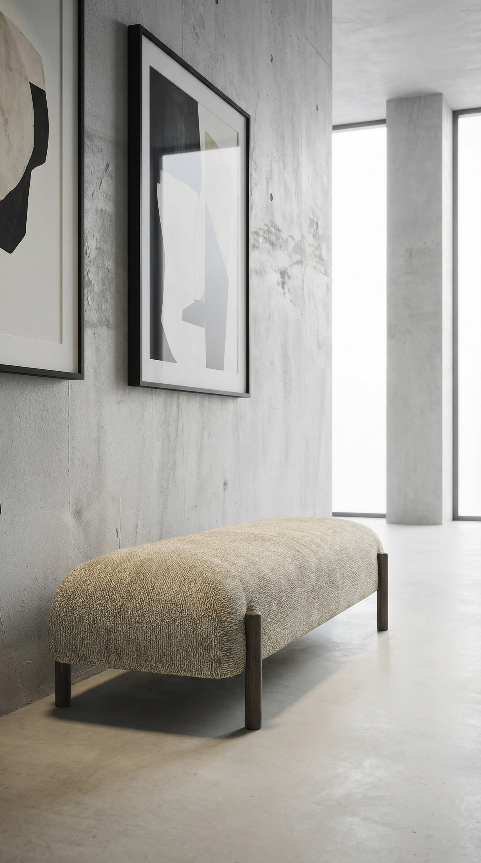 Banc rembourr&eacute; &eacute;l&eacute;gant avec un rev&ecirc;tement en tissu textur&eacute; dans un espace minimaliste avec des &oelig;uvres d'art