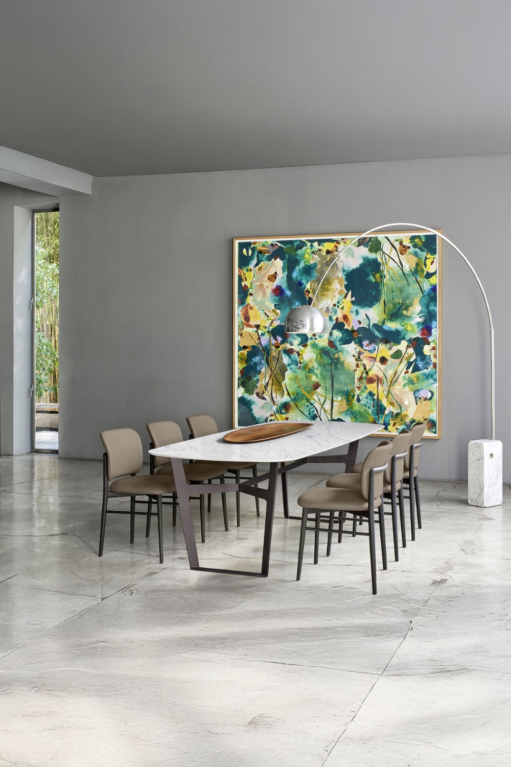 grande salle à manger carrelée avec un ensemble de table à manger au design minimaliste et une lampe arc devant une peinture murale abstraite colorée