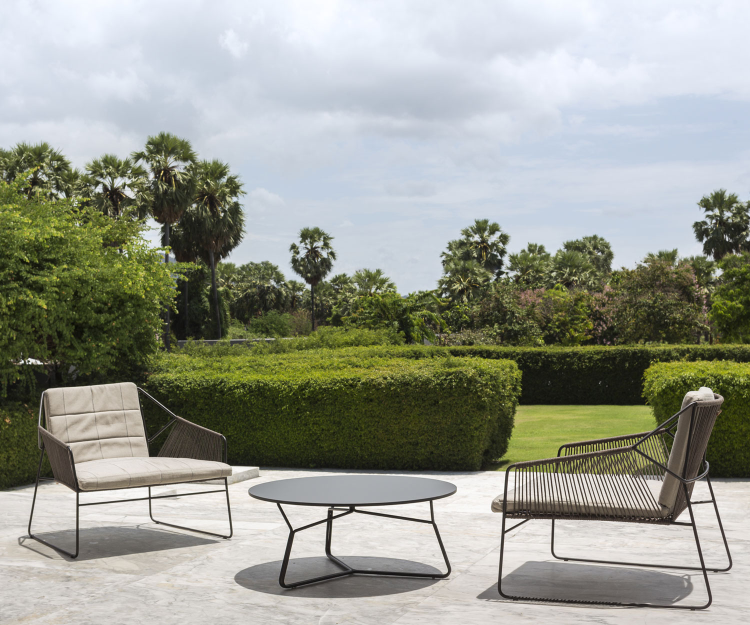 Fauteuil design exclusif Oasiq Ficelle sur la terrasse du jardin en été Fauteuil design exclusif Oasiq Ficelle sur la terrasse du jardin en été