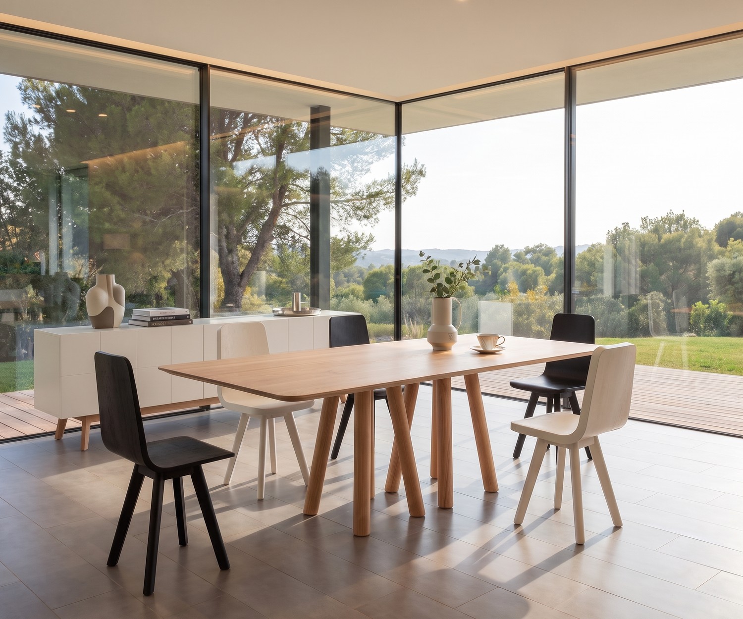 Table à manger design al2 mos-i-ko 001 a en bois massif Table de repas design al2 mos-i-ko en bois dans une salle à manger moderne, avec grandes baies vitrées et chaises.