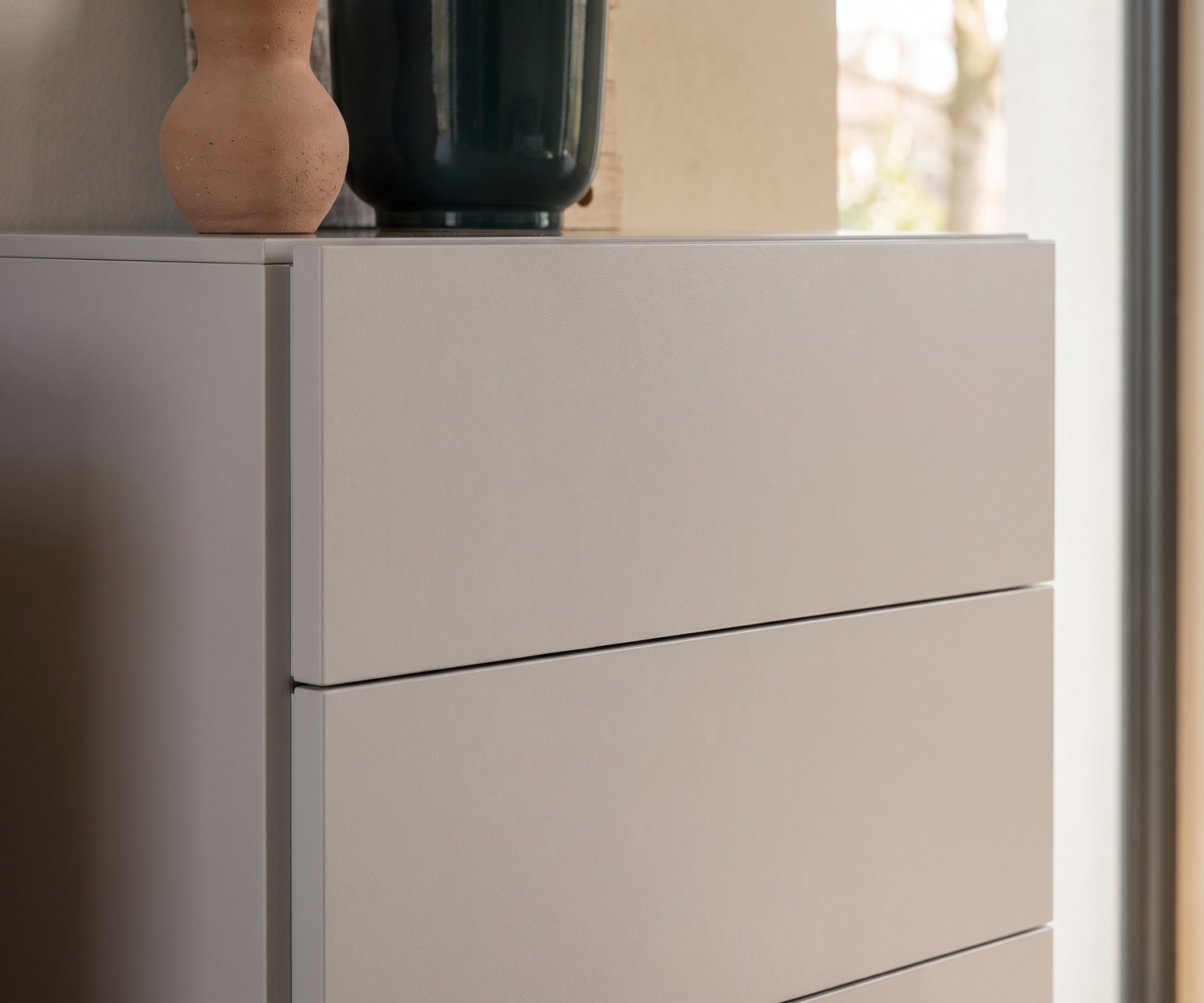 Chiffonnier Novamobili Easy pour la chambre, commode haute moderne en beige mat et sans poignée.